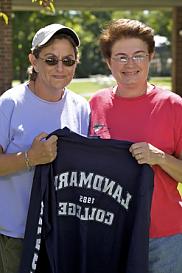 两名女子在地标学院拿着一件地标学院的t恤